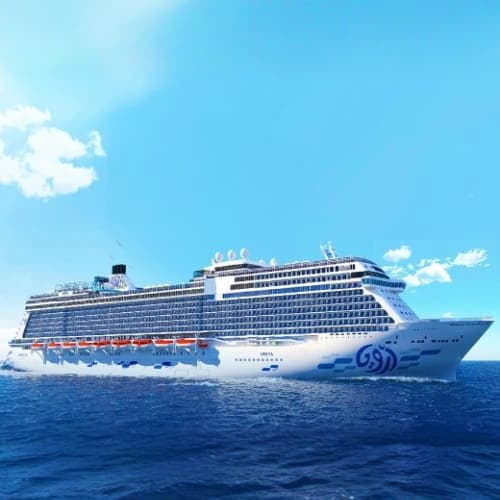 Large modern cruise ship with blue hull sailing on clear blue ocean water under bright sunny sky with white clouds