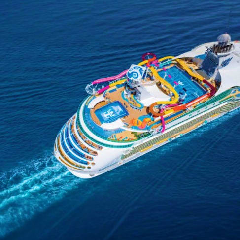 Aerial view of Navigator of the Seas cruise ship sailing on blue ocean waters with colorful deck attractions visible