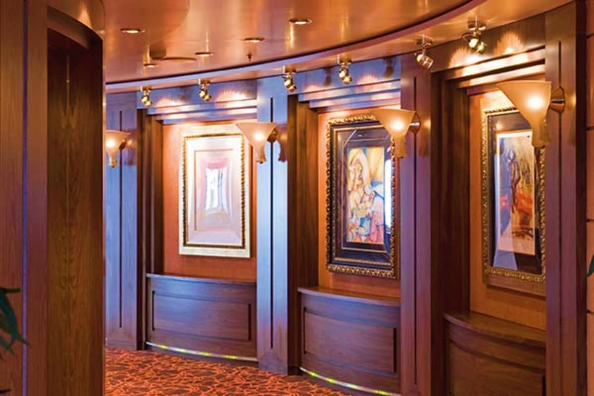 Elegant interior hallway of MSC Magnifica cruise ship with wood paneling, framed artwork, pendant lighting, and carpeted floo