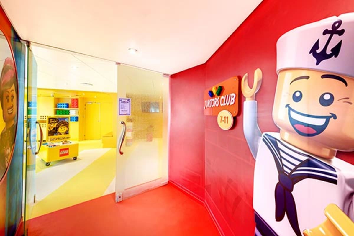 Colorful LEGO Club interior on MSC Magnifica cruise ship with bright red walls, yellow room, and smiling sailor character fig