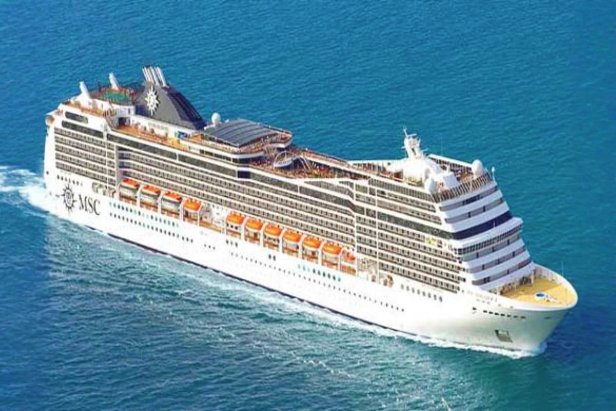 MSC Magnifica cruise ship sailing on blue ocean water, aerial view showing white hull with orange lifeboats and multiple deck
