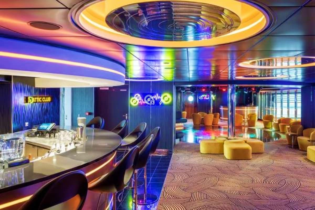 Modern nightclub interior on MSC Euribia cruise ship with colorful neon lighting, bar seating, and lounge area with yellow ot