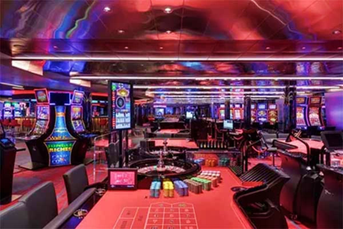 Modern casino floor with slot machines, roulette table, and gaming stations illuminated by red and blue neon lighting