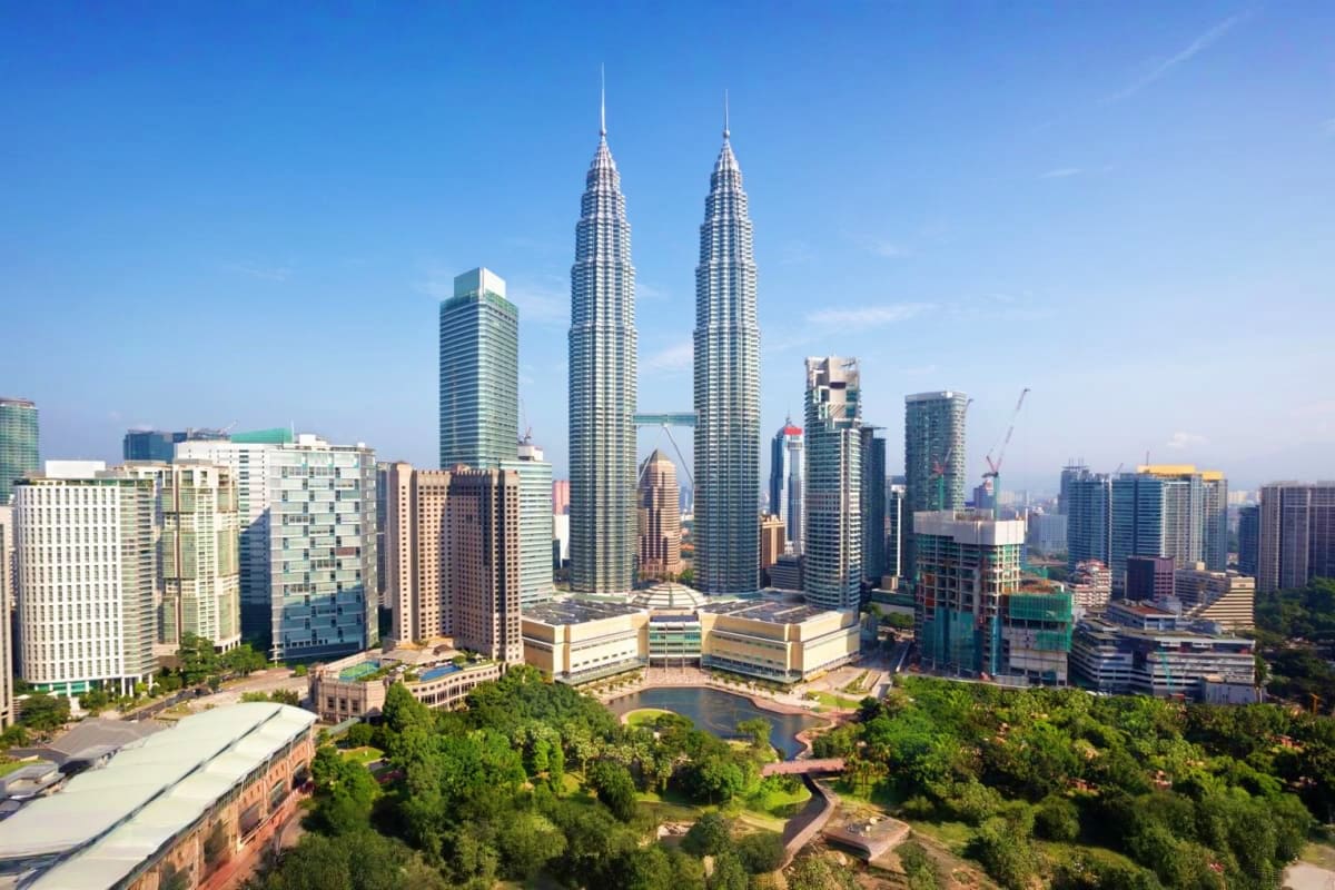 Kuala Lumpur skyline featuring the iconic Petronas Twin Towers and modern cityscape with surrounding buildings and green park