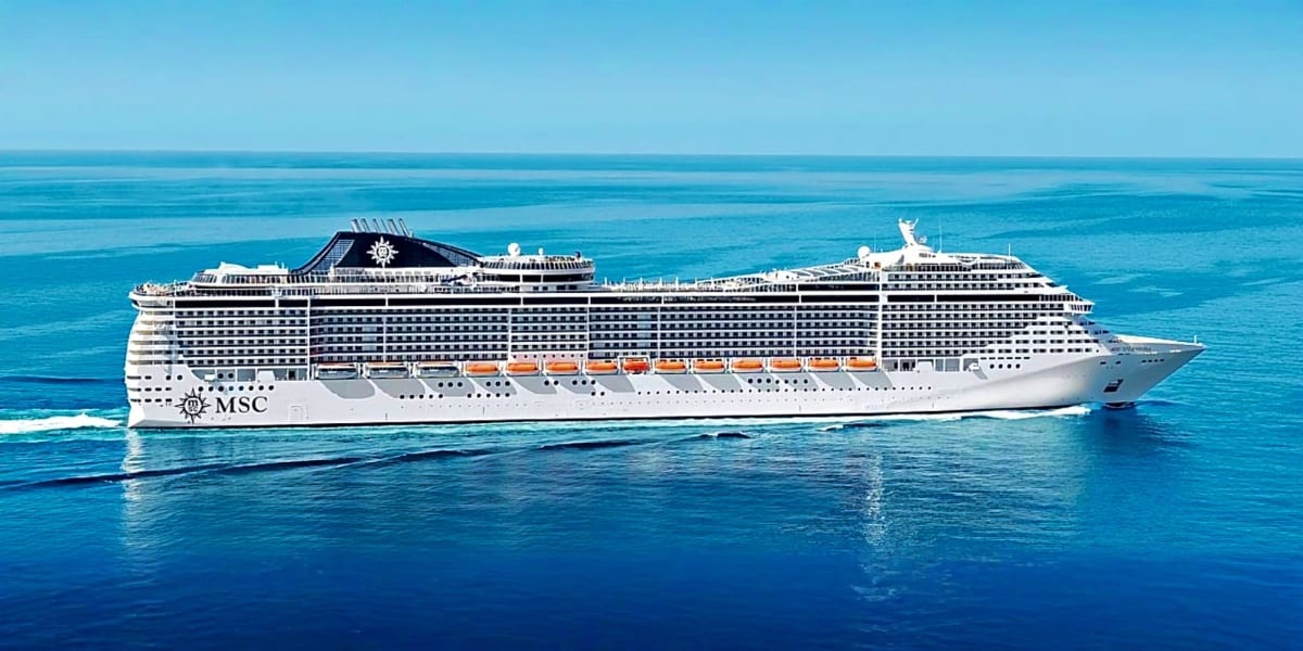 Large white MSC cruise ship anchored in turquoise tropical waters under clear blue sky