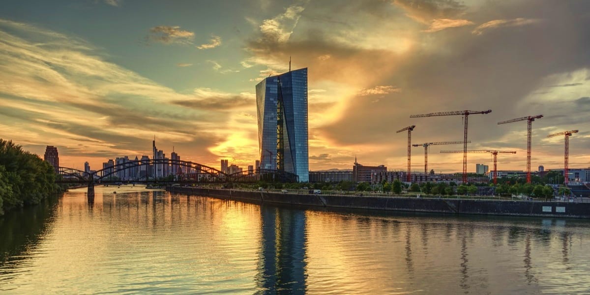 Frankfurt am Main skyline at sunset with ECB tower, iron footbridge, and river reflections