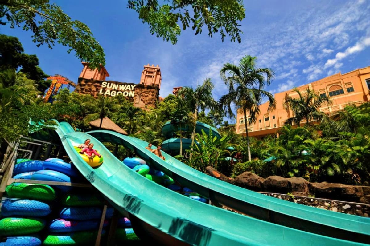 Sunway Lagoon Sunway Lagoon water park with turquoise slides, tropical palm trees, and orange castle-themed buildings under blue sky