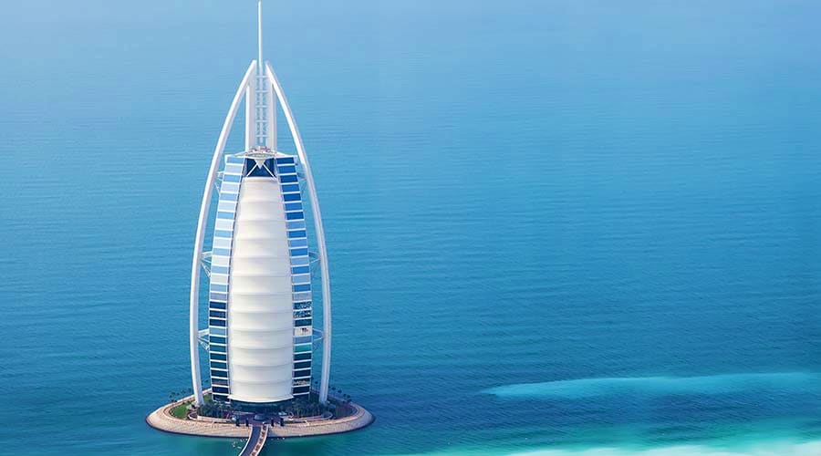 Aerial view of Burj Al Arab luxury hotel in Dubai surrounded by turquoise waters
