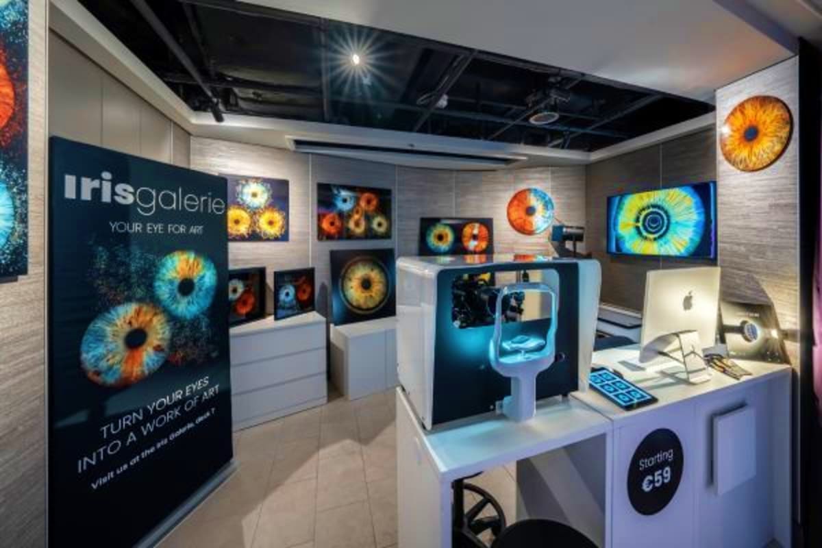 Iris Galerie art gallery retail shop interior with colorful iris eye artwork displays and digital screens on white walls