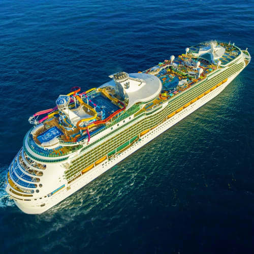 Aerial view of Navigator of the Seas cruise ship on blue ocean waters with waterslides and deck amenities visible