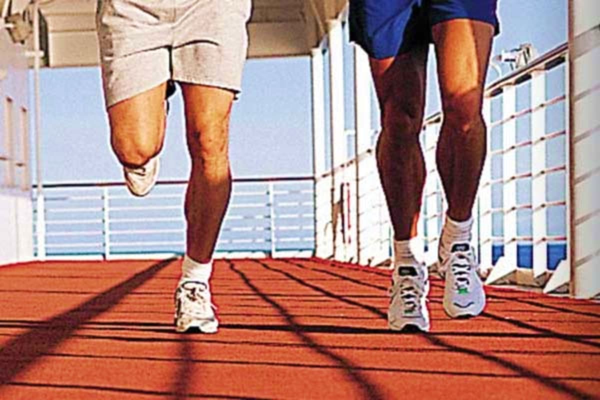 Two runners jogging on ship deck with ocean and railing visible in background
