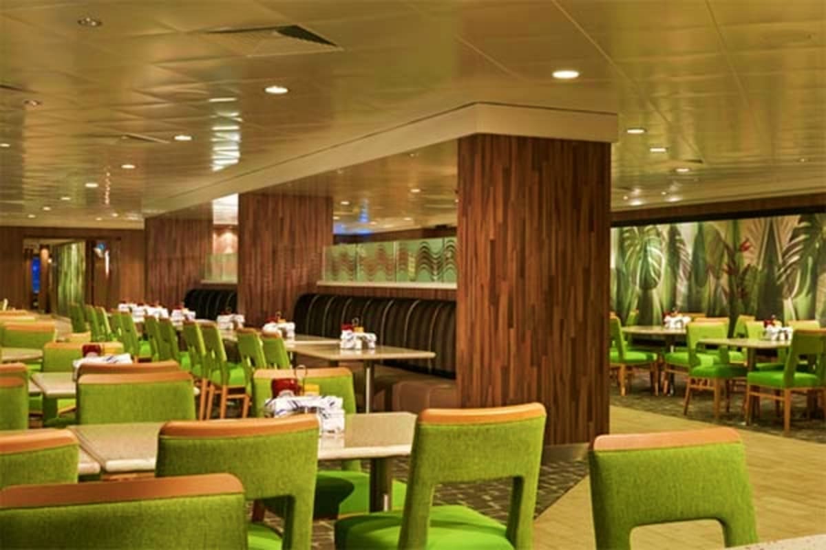 Modern cruise ship dining room with green chairs, wood columns, and tropical plant artwork on walls