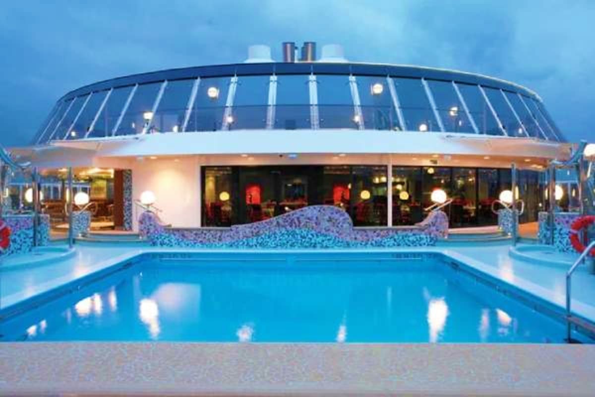 Indoor swimming pool on MSC Fantasia cruise ship at dusk with illuminated deck and modern architectural design