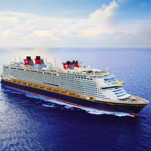 Disney cruise ship sailing on blue ocean waters under cloudy sky