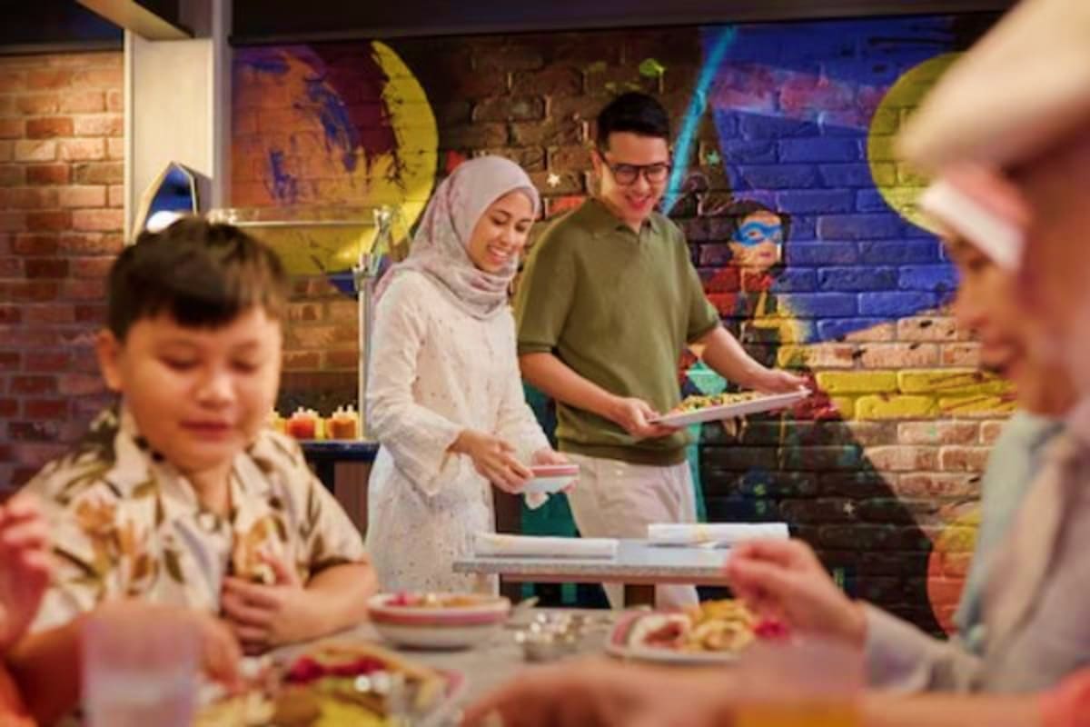 Family enjoying a festive meal together in a colorful decorated space with brick walls and vibrant artwork