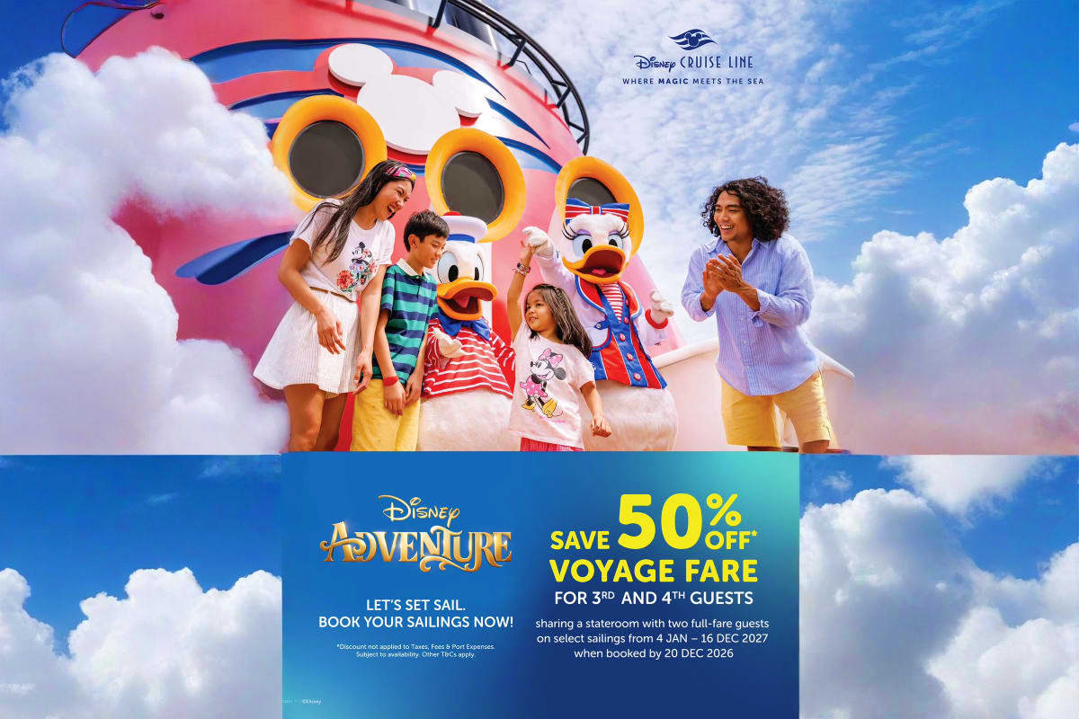 Family of five posing in front of Disney Cruise Line ship with colorful characters and blue sky with clouds