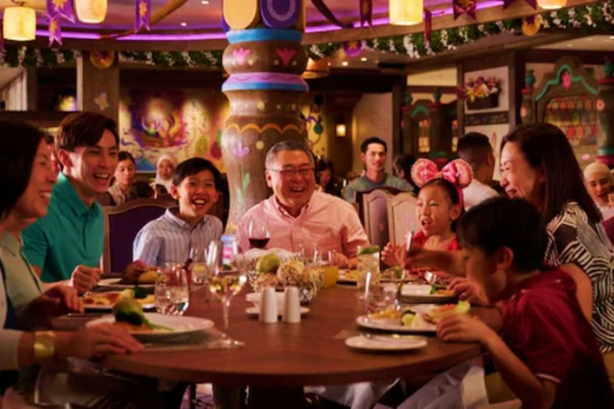 Family and friends dining together at an elegant restaurant with festive decorations and colorful lanterns overhead