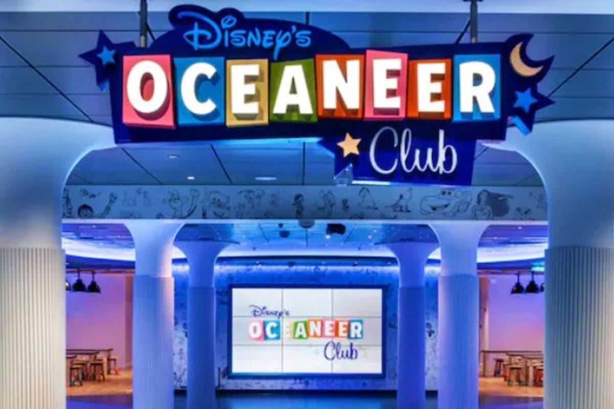 Disney's Oceaneer Club entrance sign with blue neon lighting and colorful lettering at a Disney cruise ship venue
