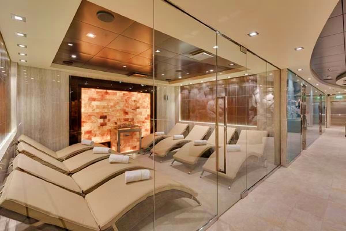Luxury spa relaxation area on MSC Magnifica cruise ship with lounge chairs, salt therapy wall, and modern glass partitions