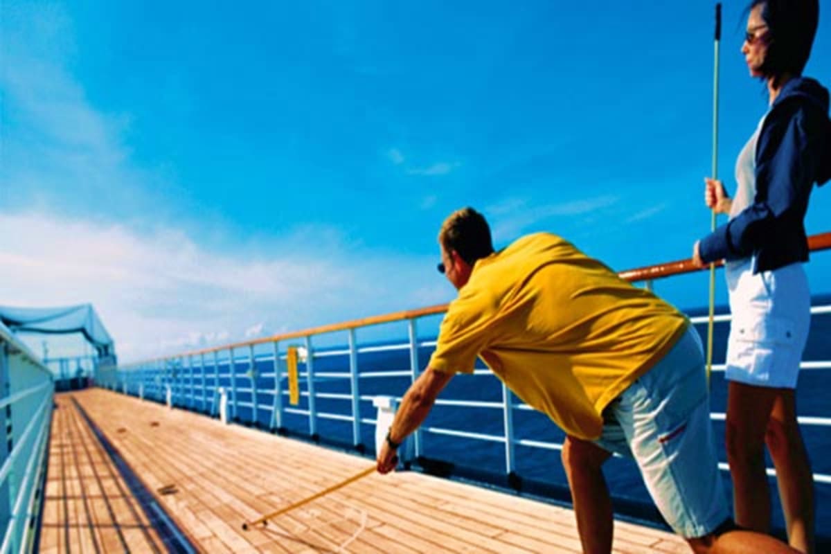 People fishing on a cruise ship deck with clear blue ocean and sky in the background