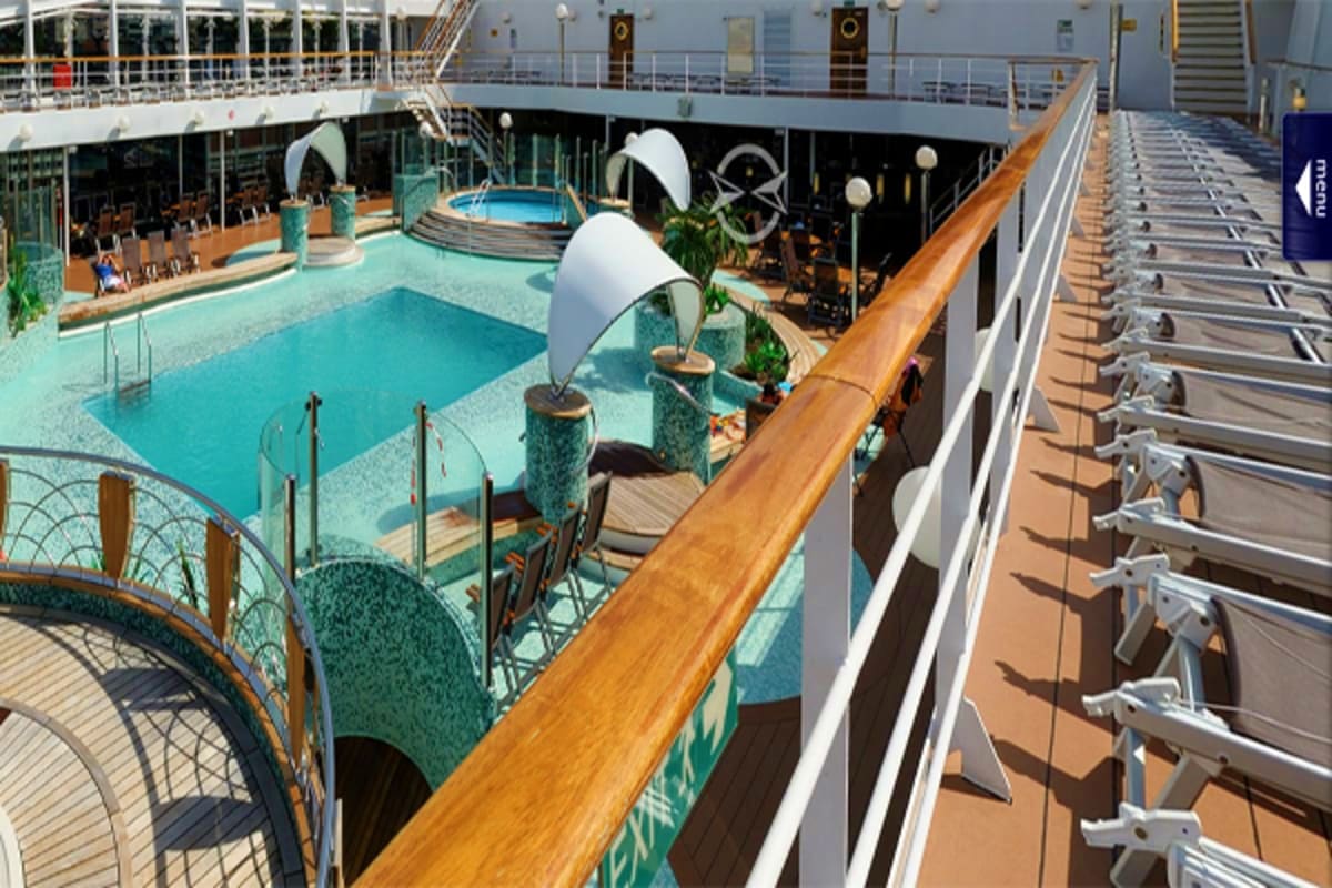 Elevated view of MSC Magnifica cruise ship deck showing swimming pool, lounge chairs, and ocean view railings