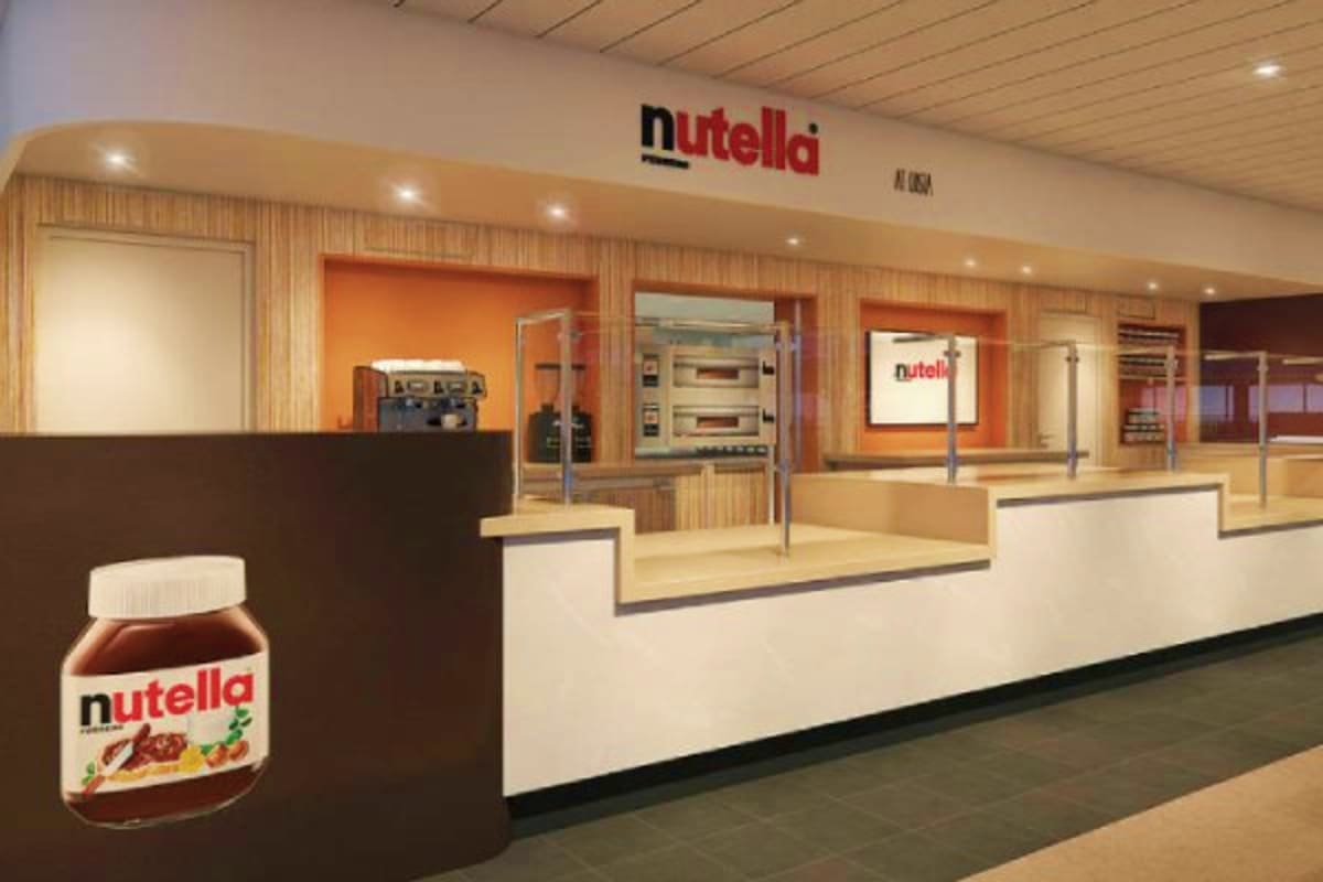 Nutella-branded café interior with large jar display, counter seating, orange accent walls, and professional kitchen equipmen