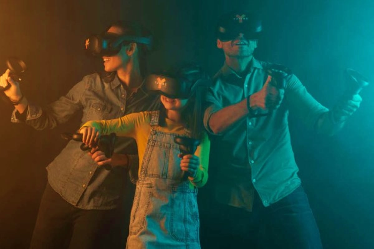 Group of people wearing VR headsets in warm and cool toned lighting, experiencing virtual reality entertainment