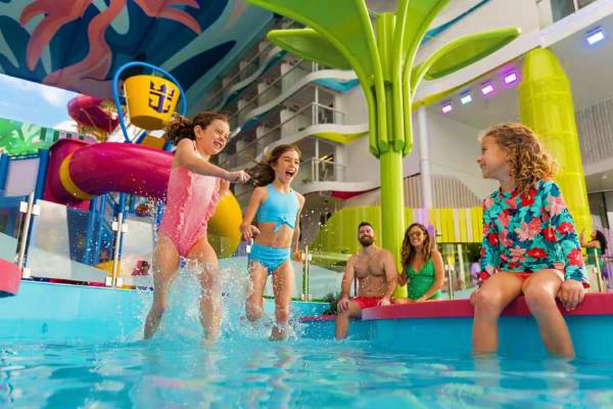 Western Mediterranean Cruise Children playing in indoor water park pool with colorful splash bucket and tropical decor on cruise ship