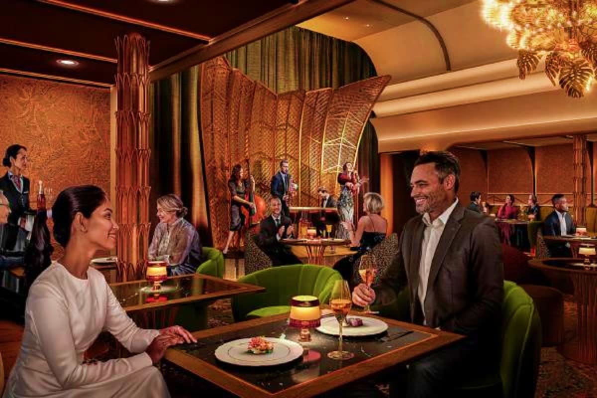 Couple dining at an elegant restaurant aboard a cruise ship with warm lighting, decorative screens, and other guests dining i