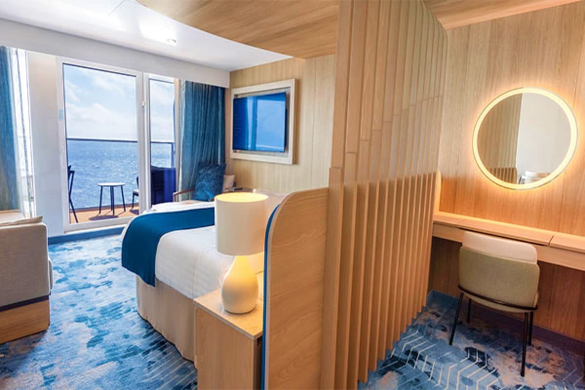 Seven Nights Western Mediterranean Royal Caribbean Legend of the Seas Luxury cruise ship cabin with ocean view, bed with blue accent, illuminated round mirror, wood paneling, and balcony overlook