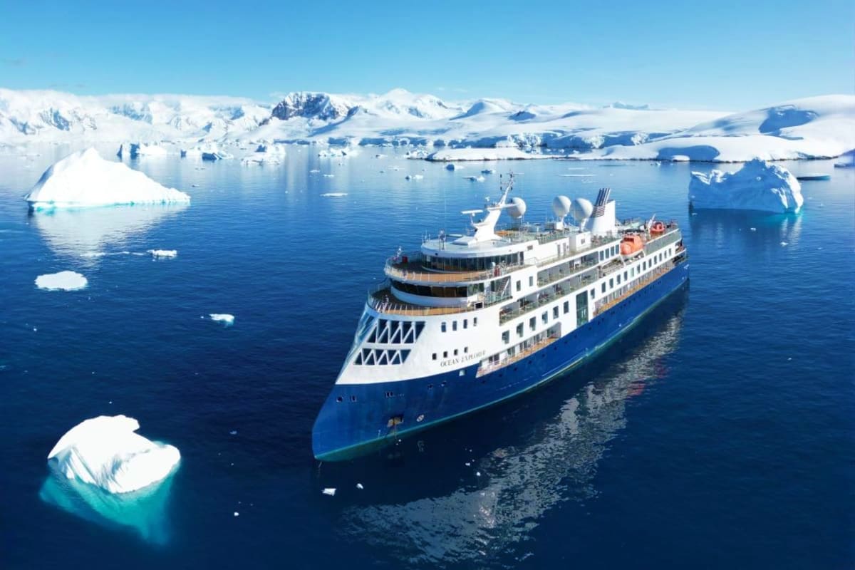 Discovering Greenland: East to West Large cruise ship navigating through icebergs and snow-covered mountains in Greenland's Antarctic waters