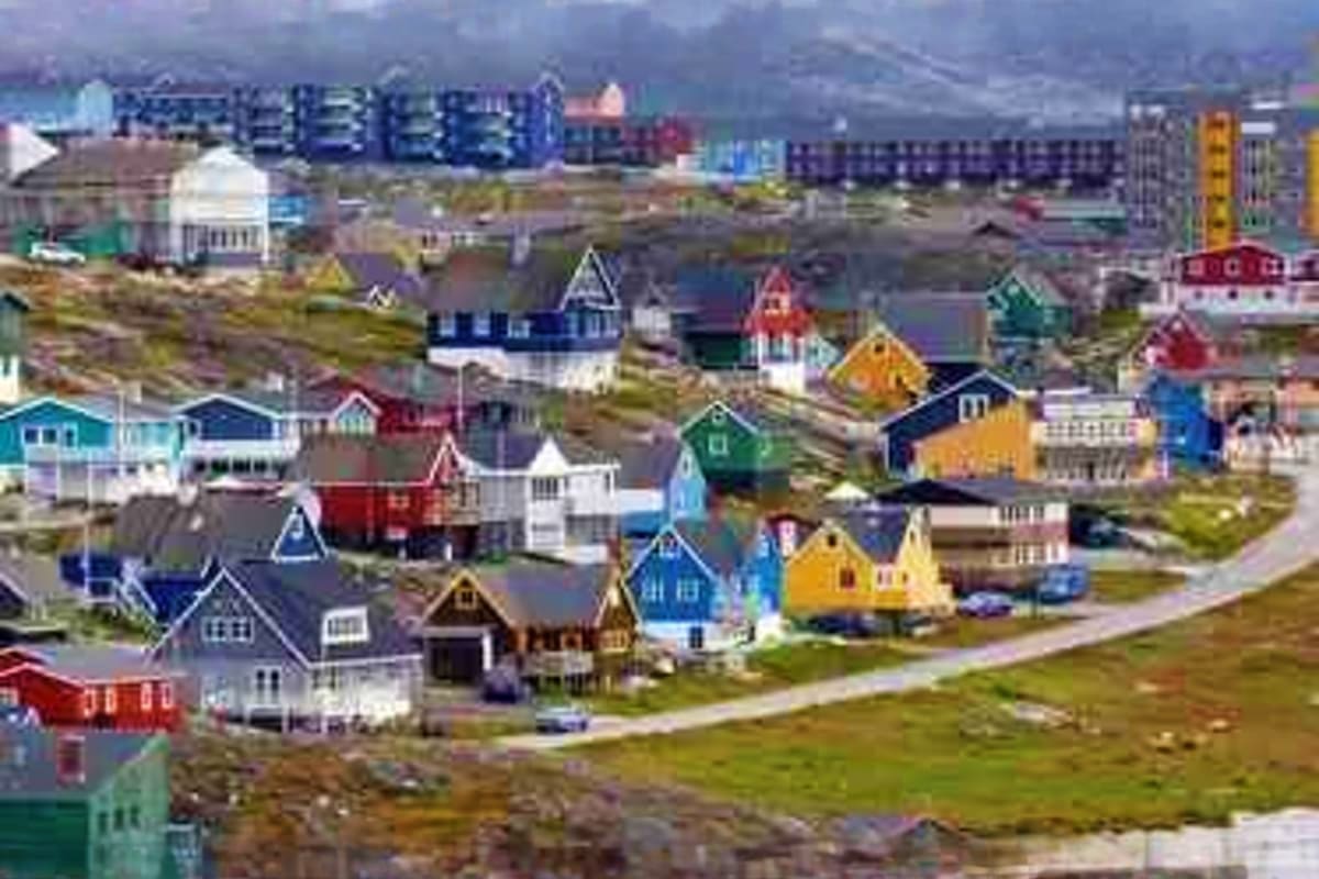 Aerial view of colorful houses in Nuuk, Greenland with mountains and modern buildings in background