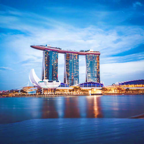 Marina Bay Sands hotel and casino illuminated at dusk reflected in calm water, Singapore skyline