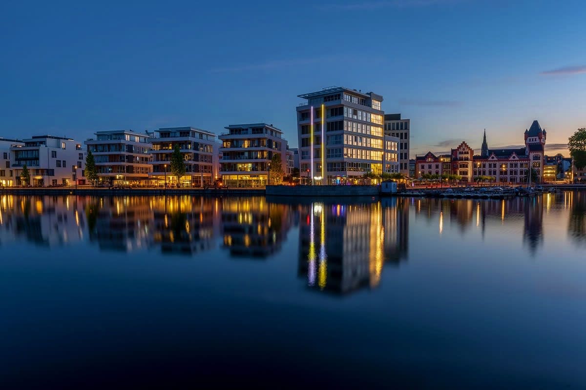 German Trek End Copenhagen Twilight view of modern waterfront buildings and historic architecture reflected in still water along a European riverfront a
