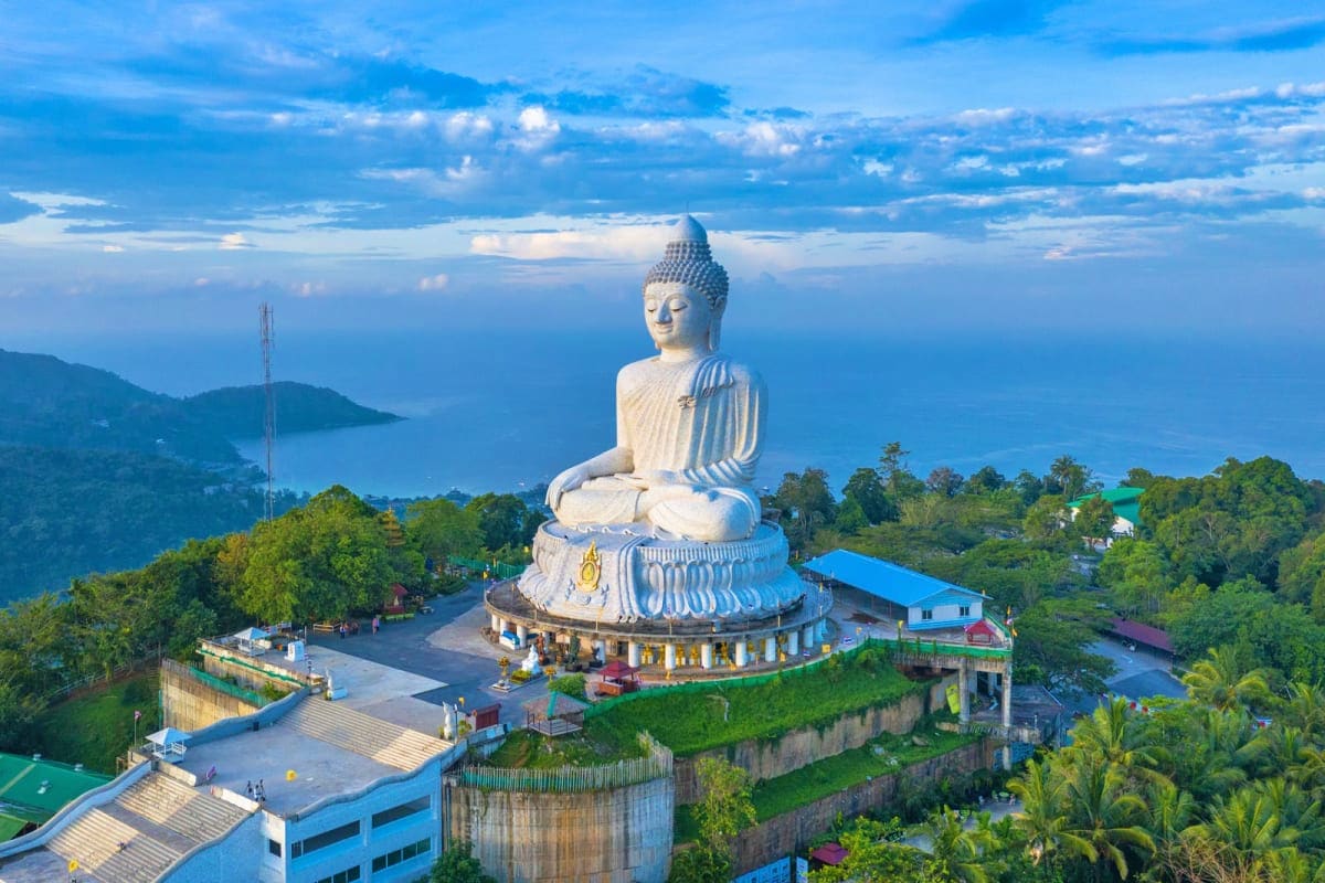 Phuket Krabi for All Ages White Buddha statue on hilltop overlooking Phang Nga Bay in Phuket, Thailand with lush tropical vegetation and coastal landsc