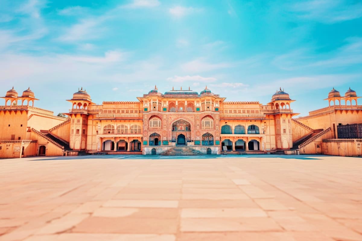 City Palace in Jaipur featuring striking pink and orange architecture with domed towers and a large courtyard under blue sky