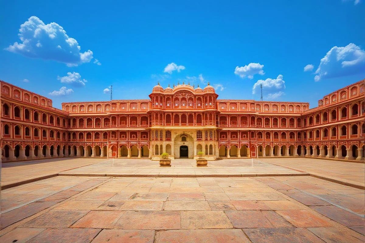 City Palace courtyard in Jaipur with red sandstone architecture and ornate arches under blue sky
