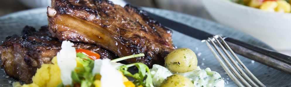 Grillede svinekoteletter med blomkålssalat, pestokartofler og tzatziki Grillede svinekoteletter med blomkålssalat, pestokartofler og tzatziki