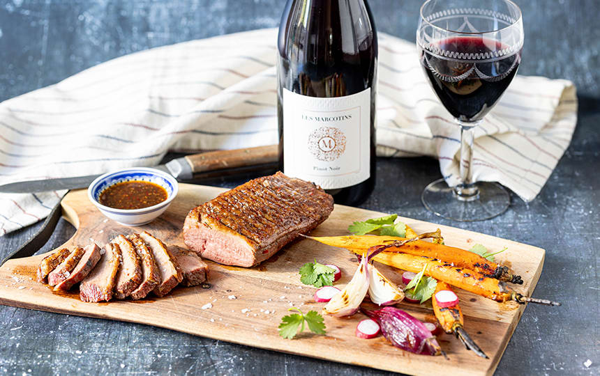 Asiatisk grillet andebryst banner med vin og skærebræt