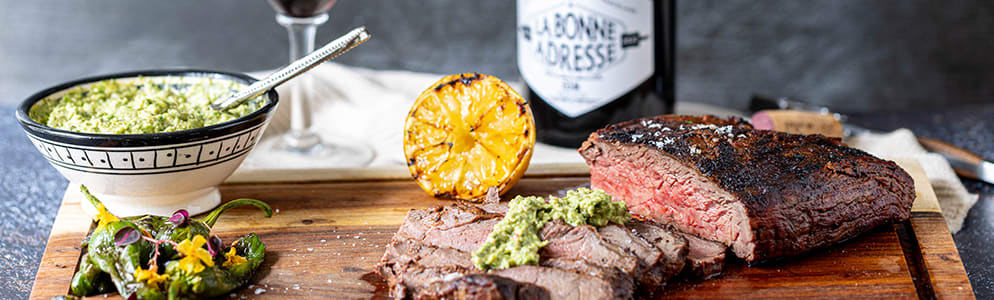 Flap Meat Header Flap Meat med tilbehør og vin på et skærebræt