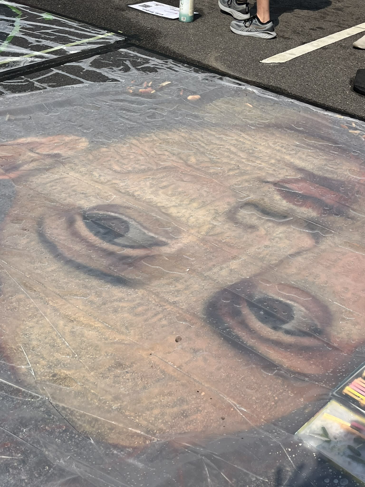 Rain falls, tarp goes over the unfinished piece