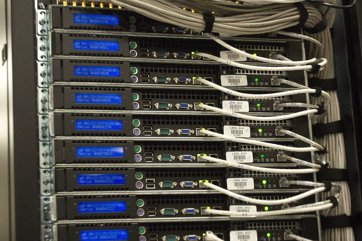 Photo of the back of a server rack at the NERSC data center, with rows of 1U servers and white Ethernet cables