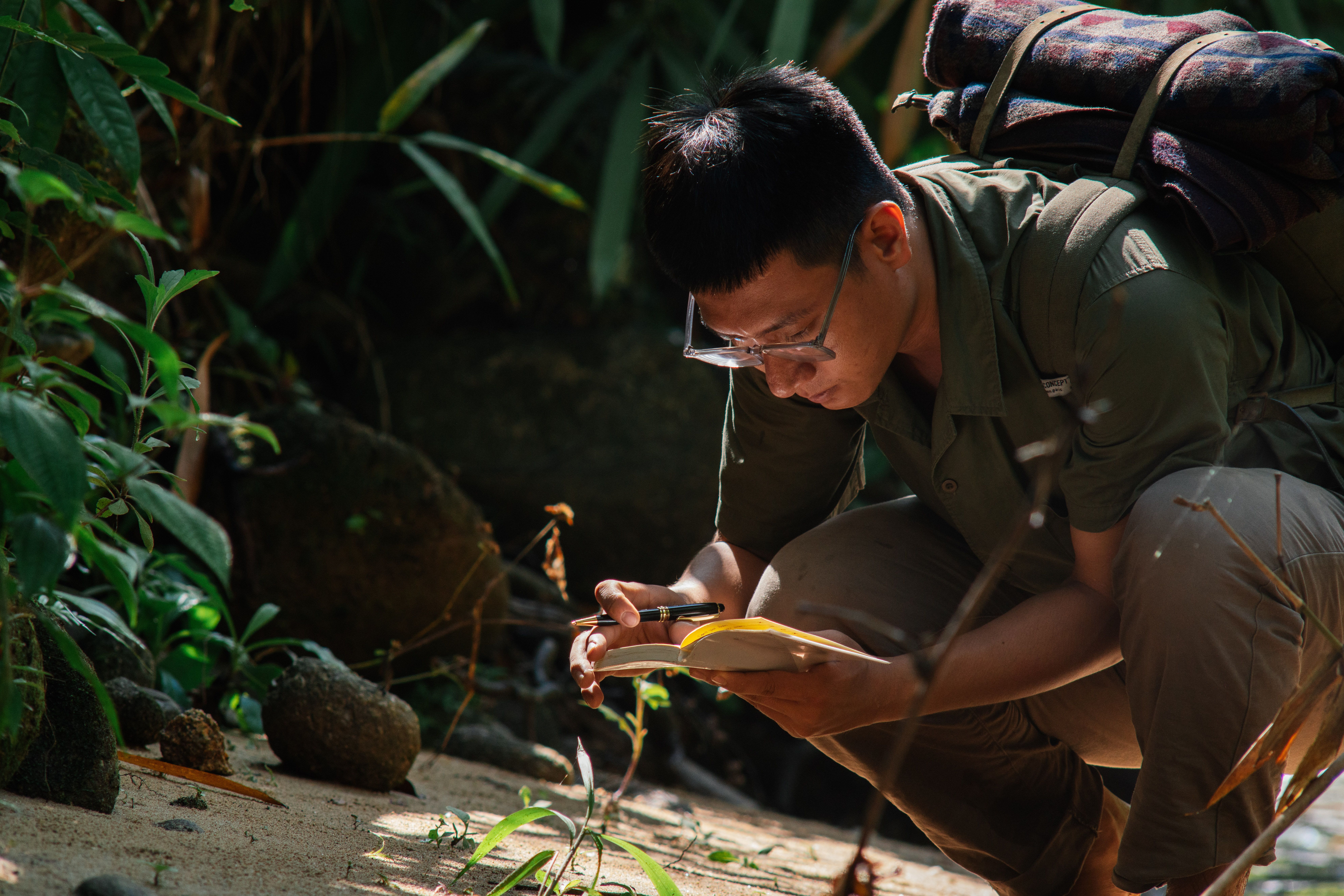 Researchers recording data with field equipment outdoors during an expedition