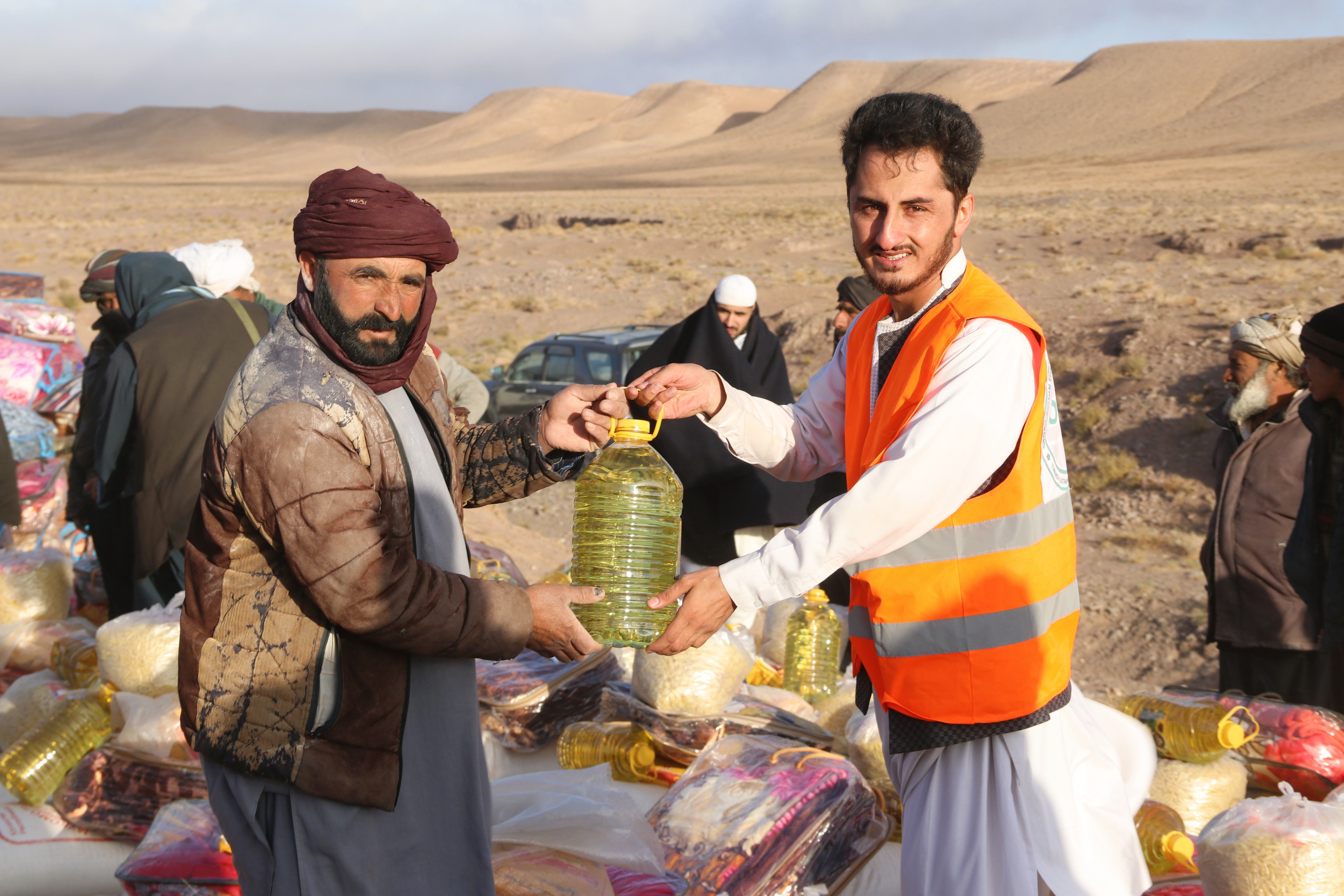 Aid workers distributing relief supplies to families at a refugee camp