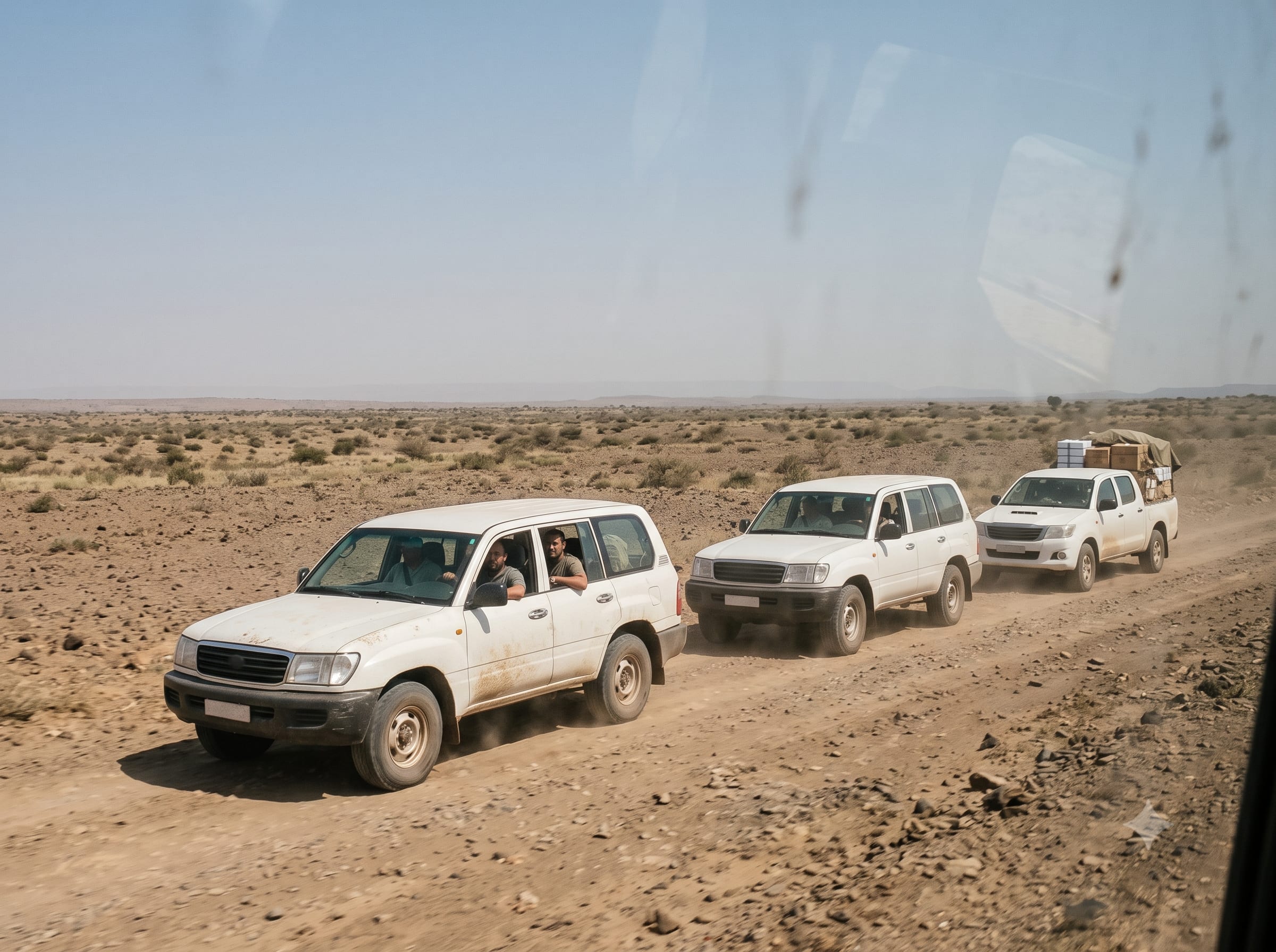 Humanitarian aid convoy travelling on a remote road in a crisis zone