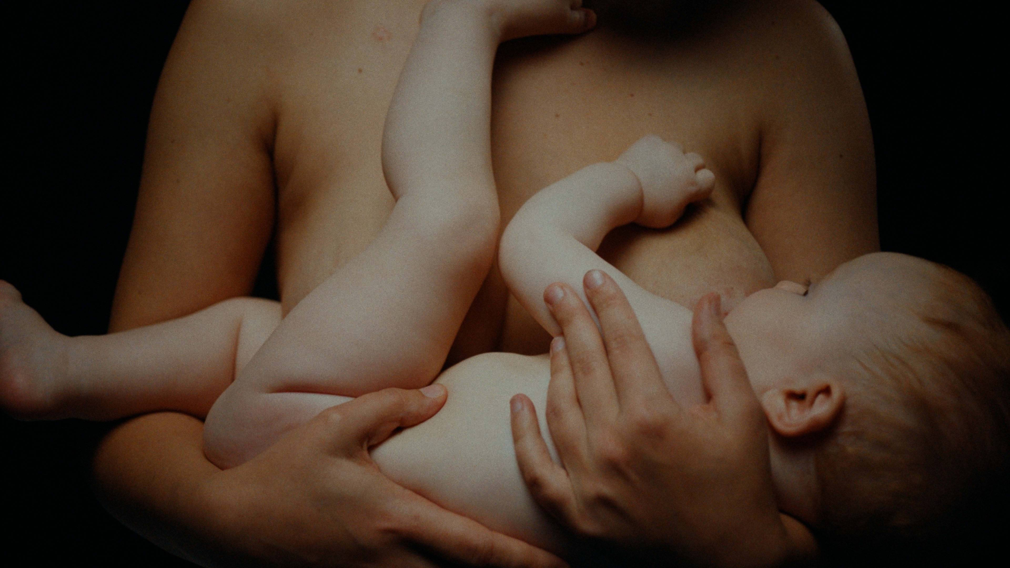 Zärtliche Stillaufnahme, warmes Color-Grading betont Hauttöne und intime Stimmung.