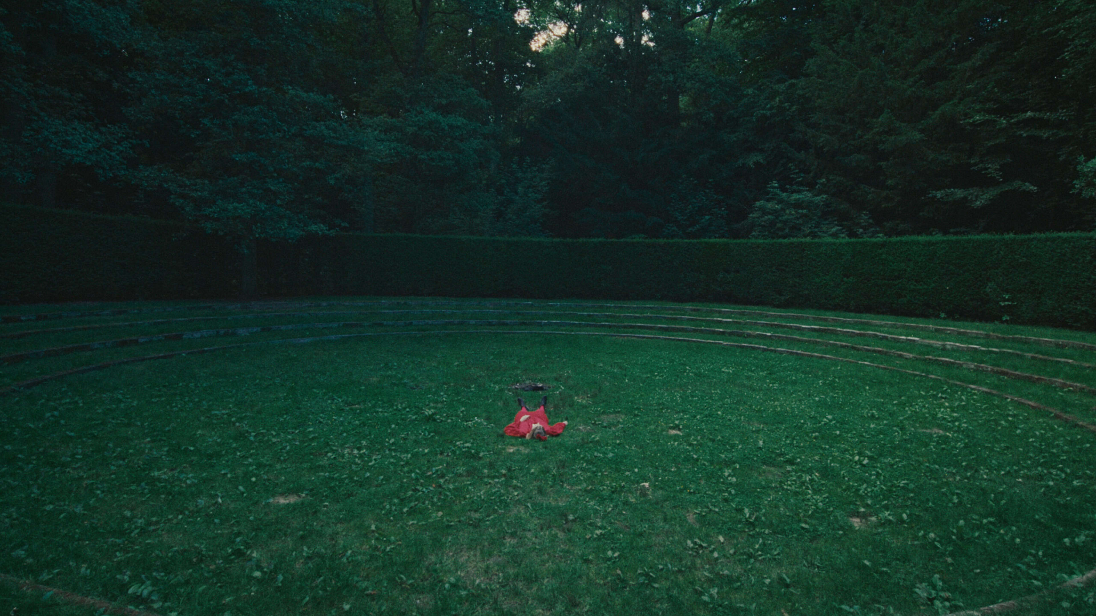 Ein Colorist bearbeitet ein Bild von einer Person in Rot im grünen Kreis, mit stimmungsvollem grading.