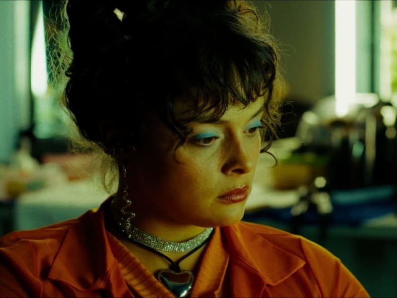 Intensives Color-Grading betont Grün-Orangetöne und blaue Akzente im Porträt.