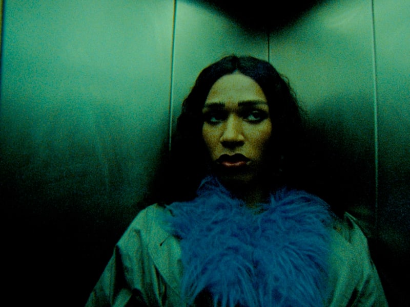 Intensives Color-Grading: Person im teal-grünen Lift, blauer Schal, dramatische Stimmung.