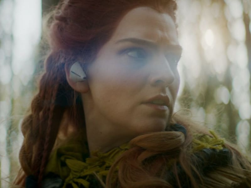 Filmisches color-grading einer rothaarigen Jägerin im Wald mit warmen Lichtstimmungen und atmosphärischen Erdtönen.